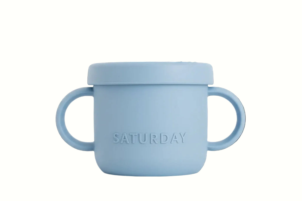 Light blue children's cup with handle and lid on a white background